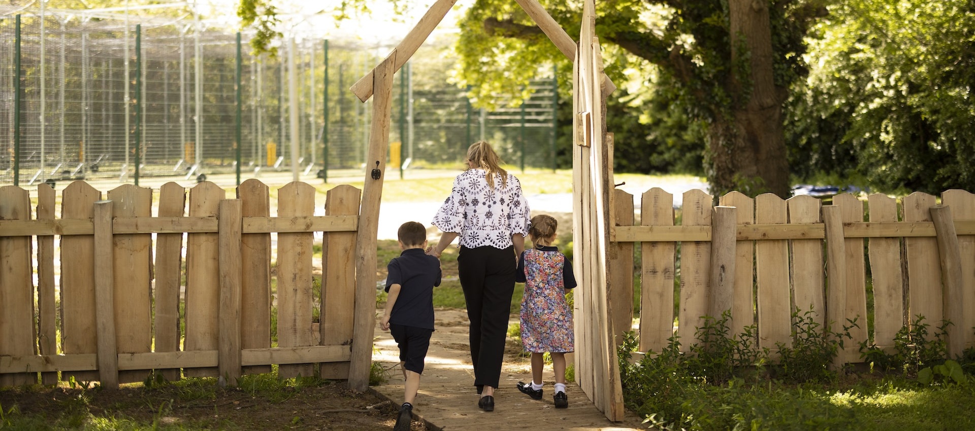 prep pupils holding hands of the teacher at the forest school of Ibstock Place School, a private school near RichmondP